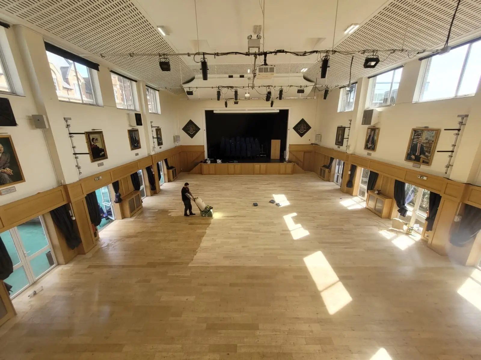 Floor sanding in progress on a large London commercial hall, the timber taken back to bare wood