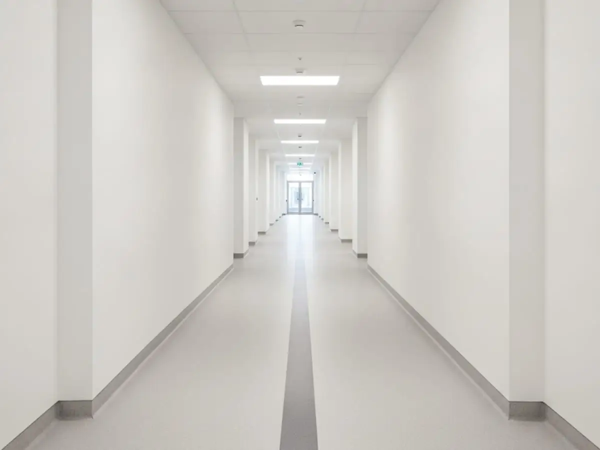 Clean, compliant commercial flooring in a modern London corridor with clear signage