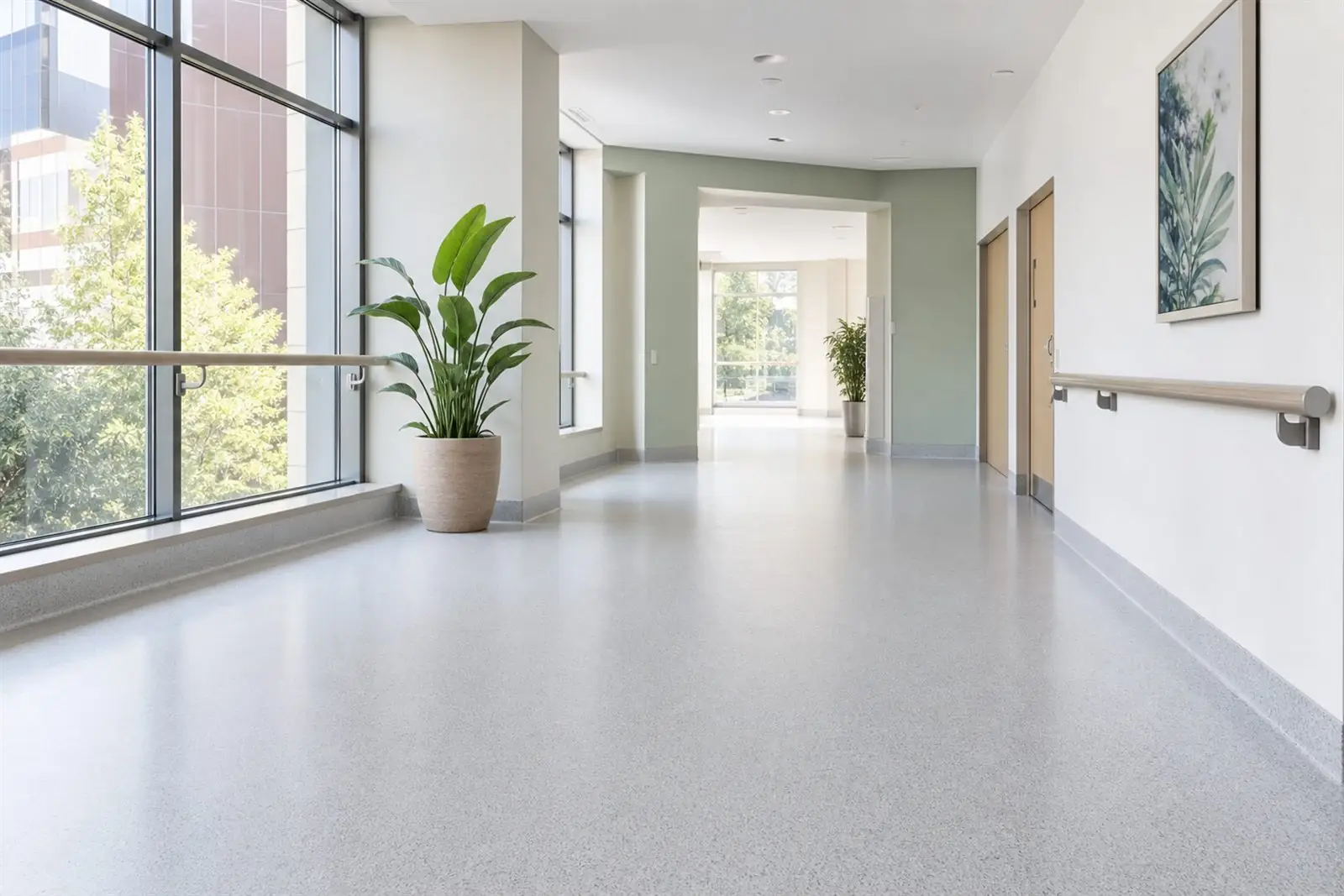 Bright, clean seamless safety flooring with coved skirting in a modern hospital corridor